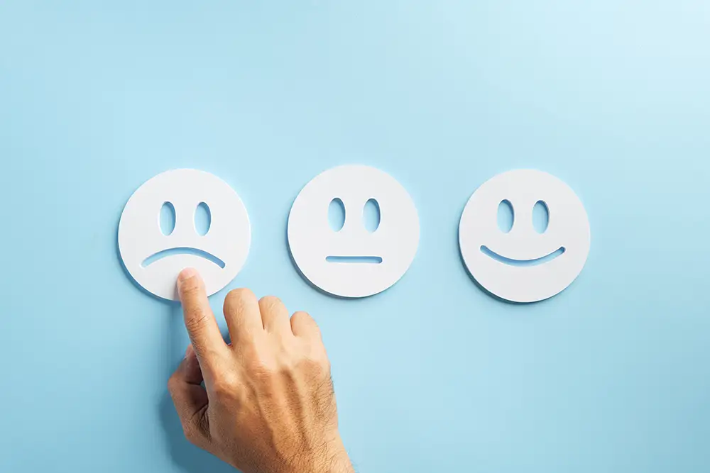 Finger zeigt auf einen traurigen Smiley