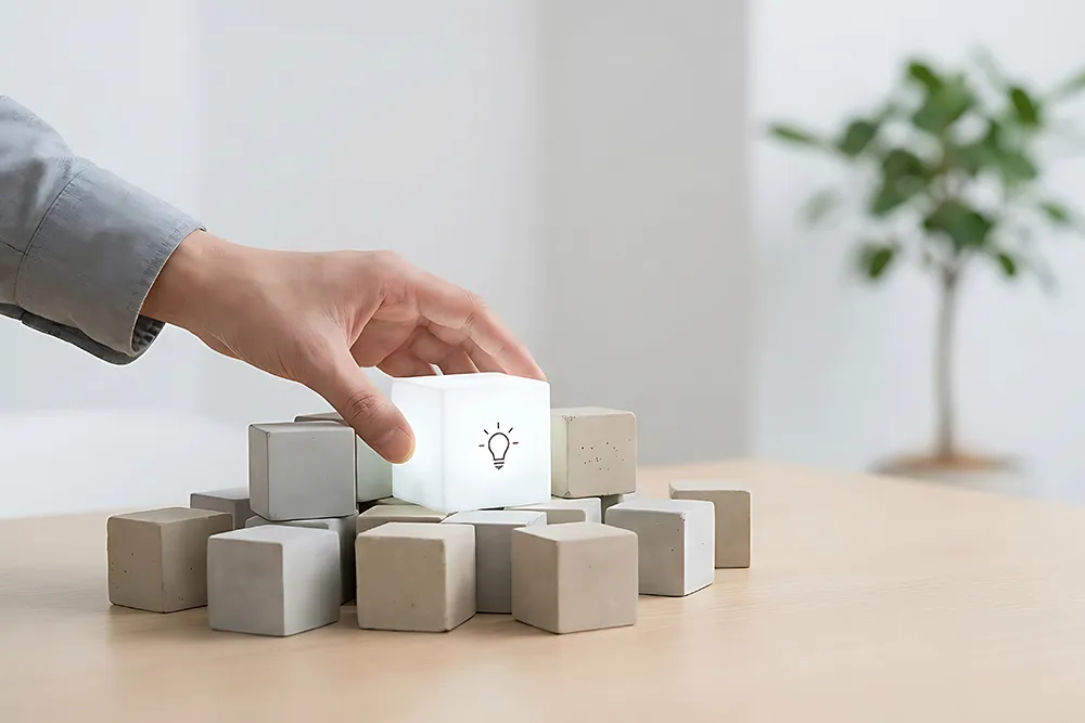 Eine leuchtender Block wird von Hand auf Betonblöcke gesetzt